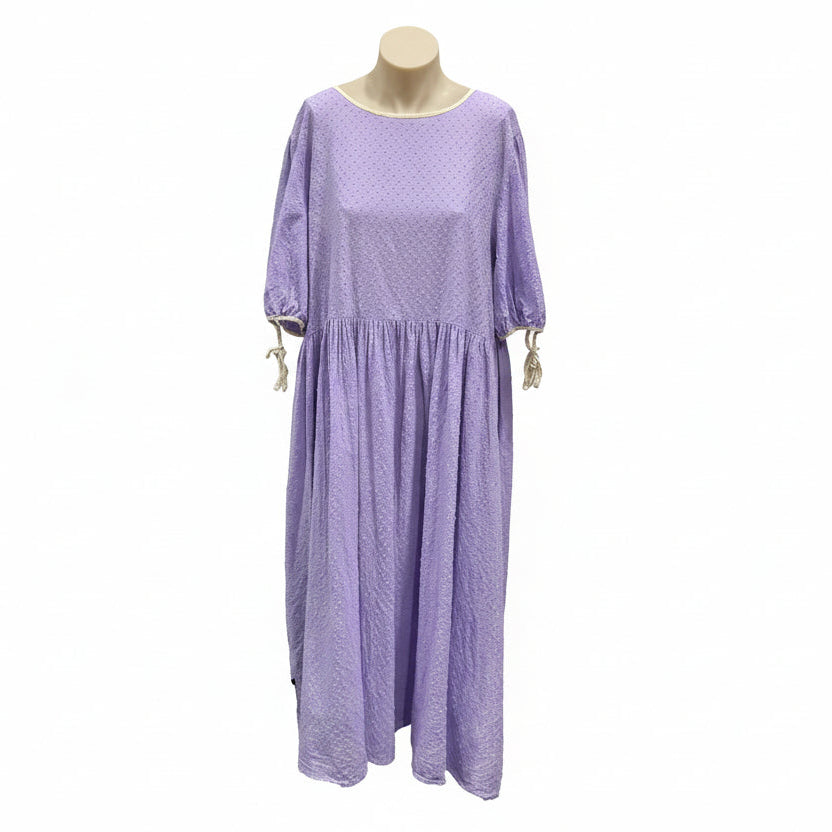 Purple dress on a mannequin against a white wall