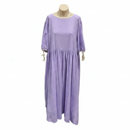 Purple dress on a mannequin against a white wall